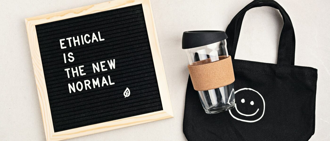 Ethical is the new normal letterboard text. Black organic cotton eco bag and reusable coffee cup